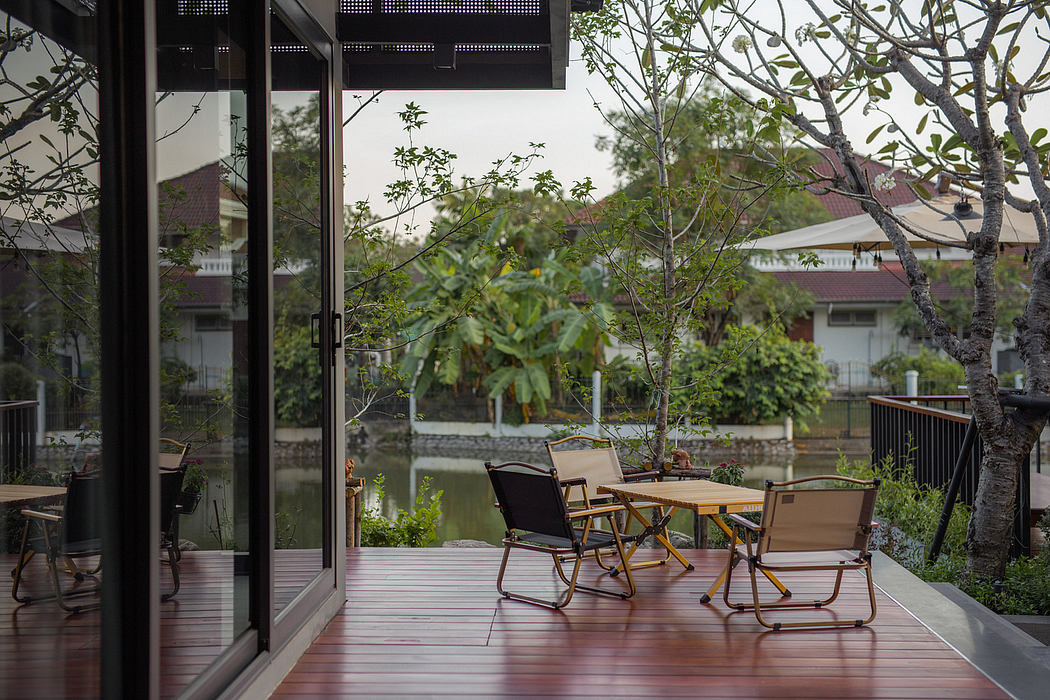 Outdoor wooden deck with chairs and a table, overlooking a tranquil waterway.