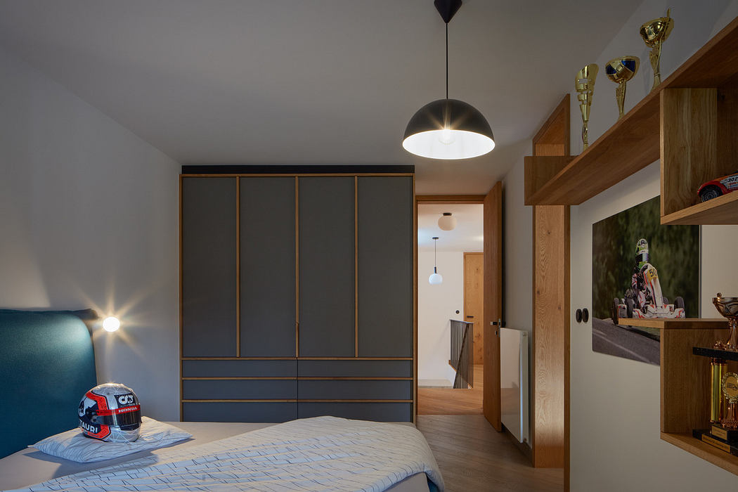 Modern bedroom with blue headboard, trophy shelf, and pendant light.