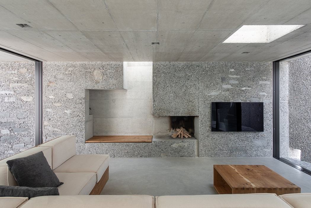 Minimalist living room with concrete walls and embedded fireplace.