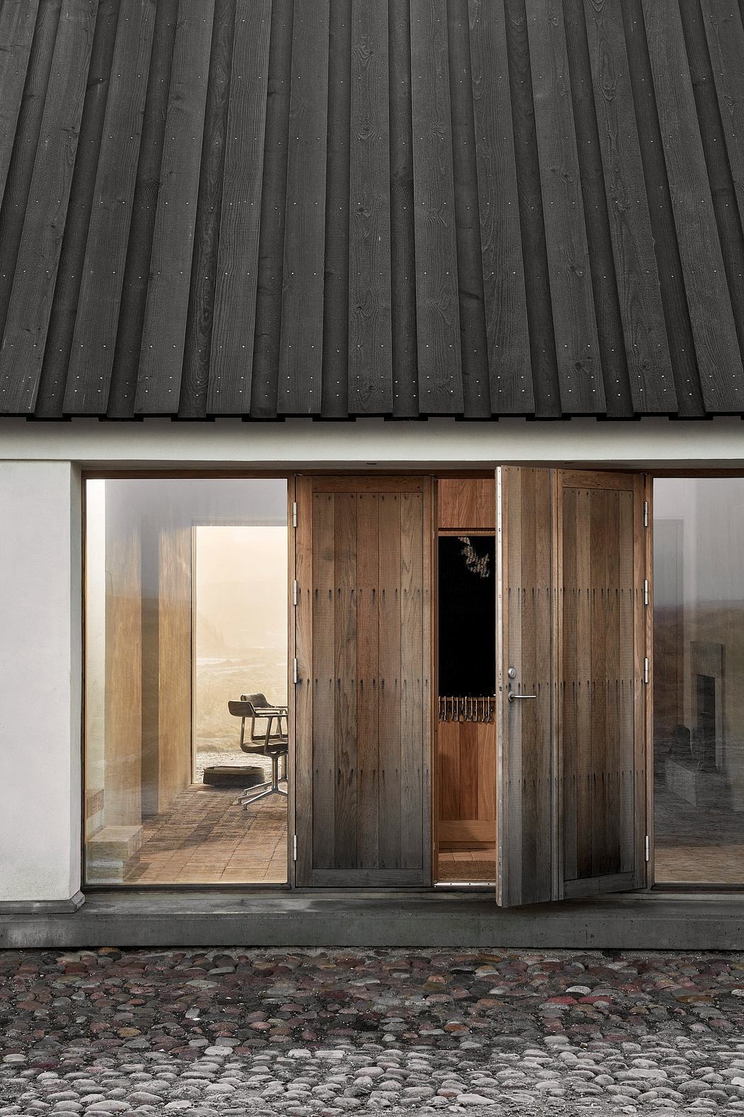 Modern house facade with black roof, wooden door, and large window.