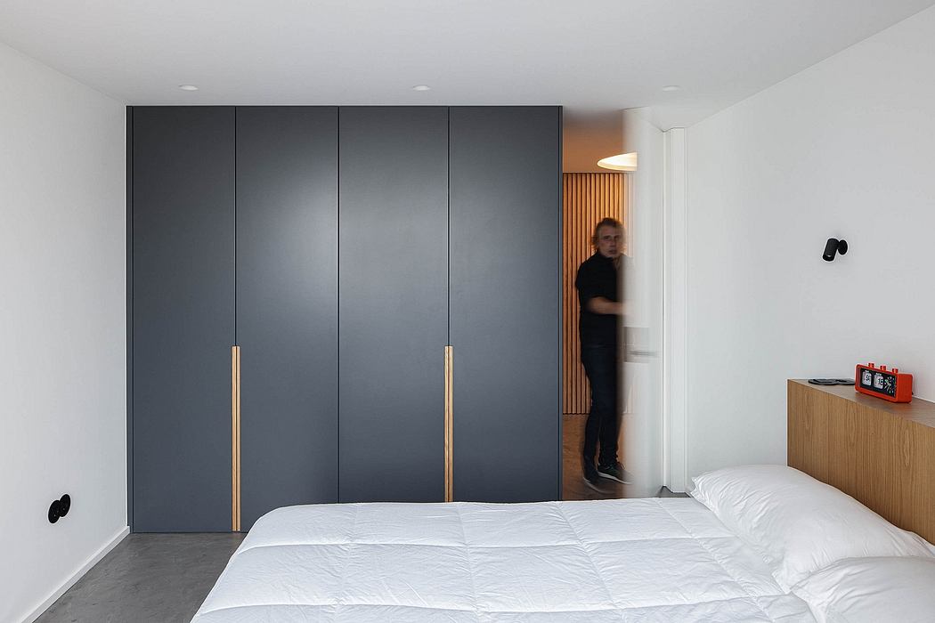 Modern bedroom with a large gray closet and a person in the doorway.