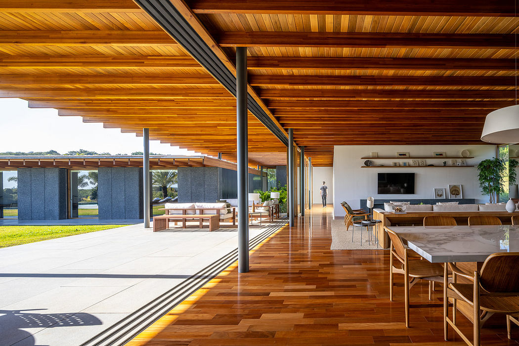 Modern home interior with wooden floors and ceiling, extending to an outdoor patio.