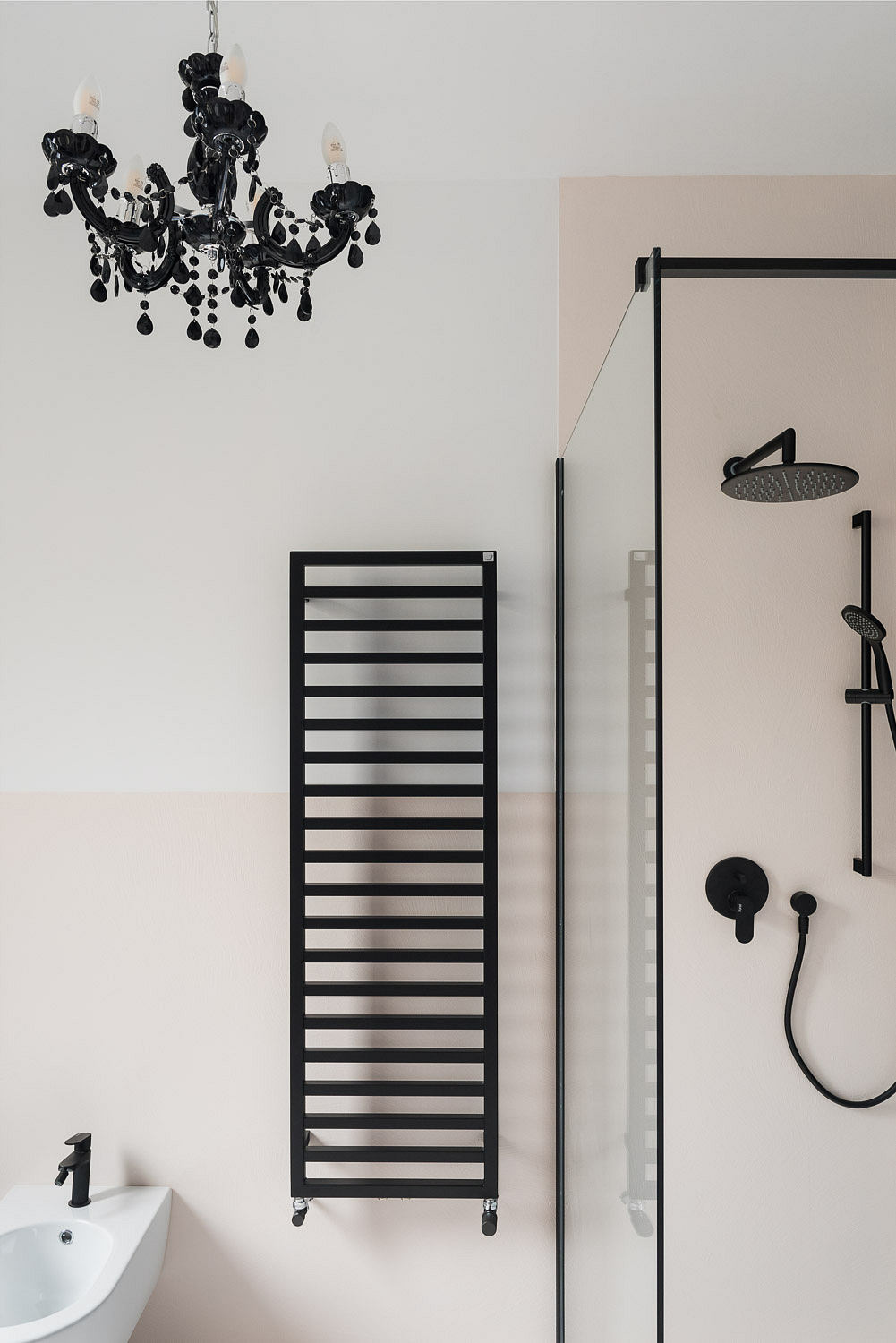 Elegant bathroom with a black chandelier and a towel warmer.