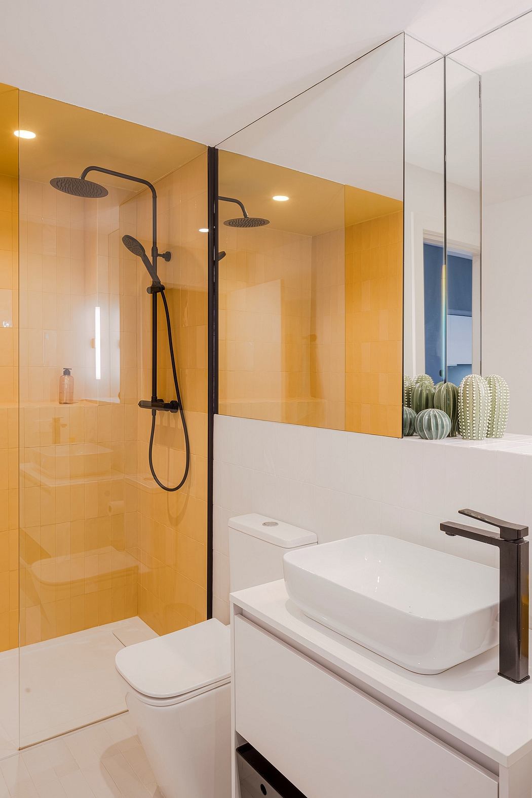 Modern bathroom with a glass shower, yellow tiles, and a white basin.