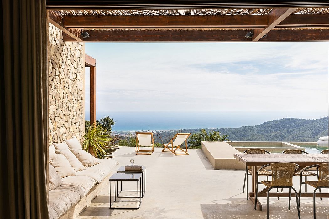 Elegant patio with stone wall, ocean view, and wooden accents.