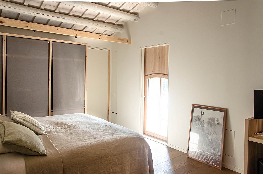 Modern bedroom with a large bed, wooden ceiling, sliding doors, and framed artwork