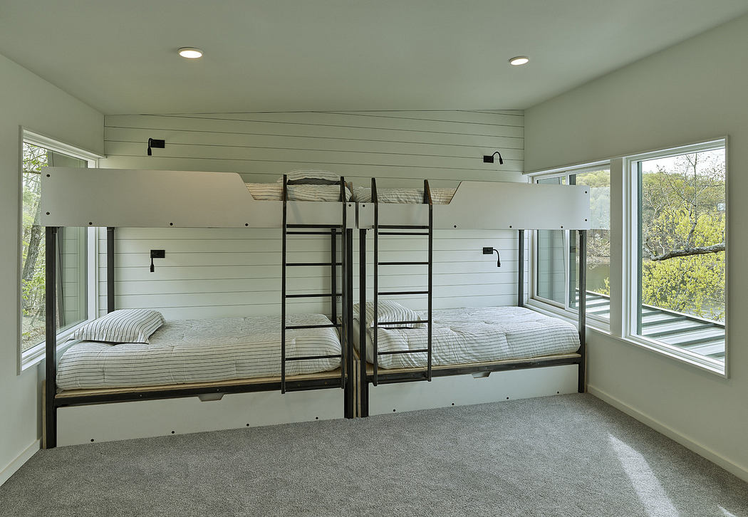Bright bedroom with built-in bunk beds and large windows.