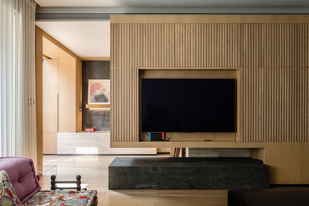 Modern living room with wooden slat walls and mounted TV.