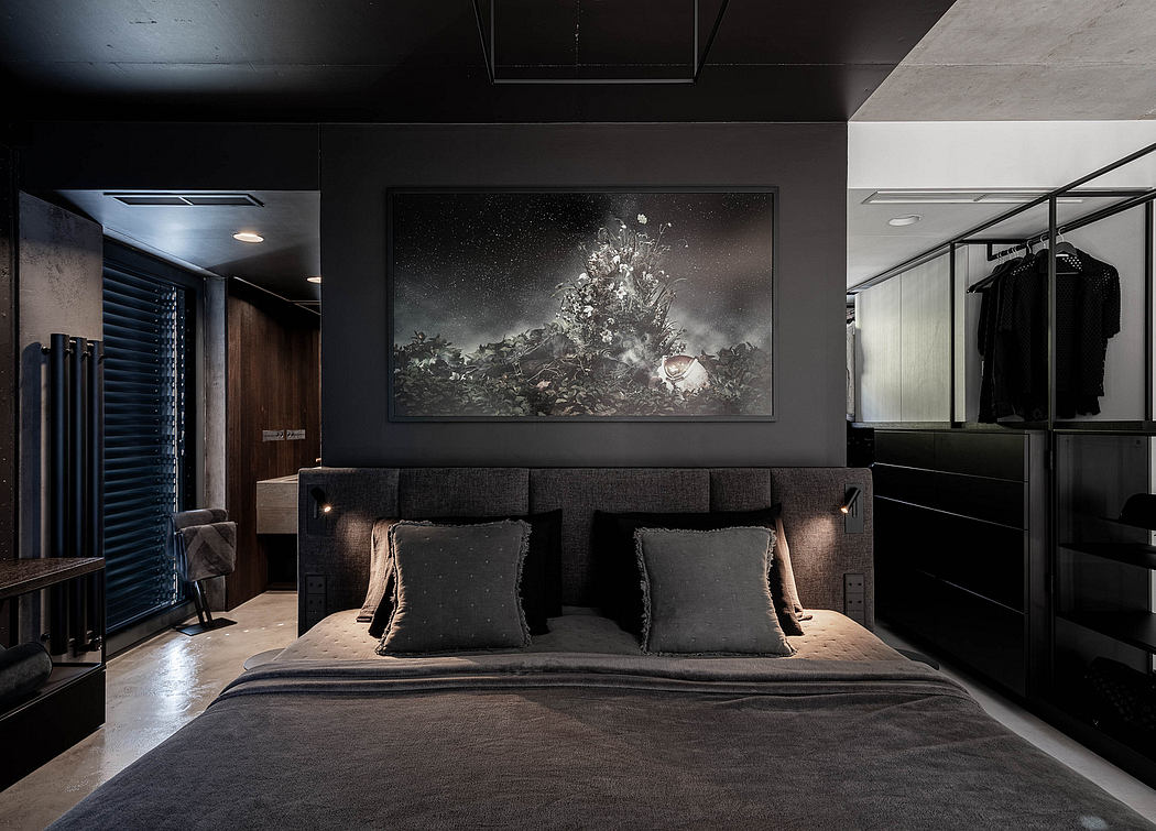 Contemporary bedroom with dark tones, large art over bed, and mirrored wardrobe.