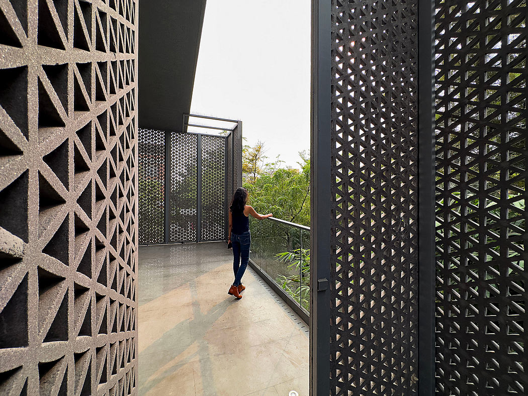 Woman opening geometric patterned screen door in modern hallway.