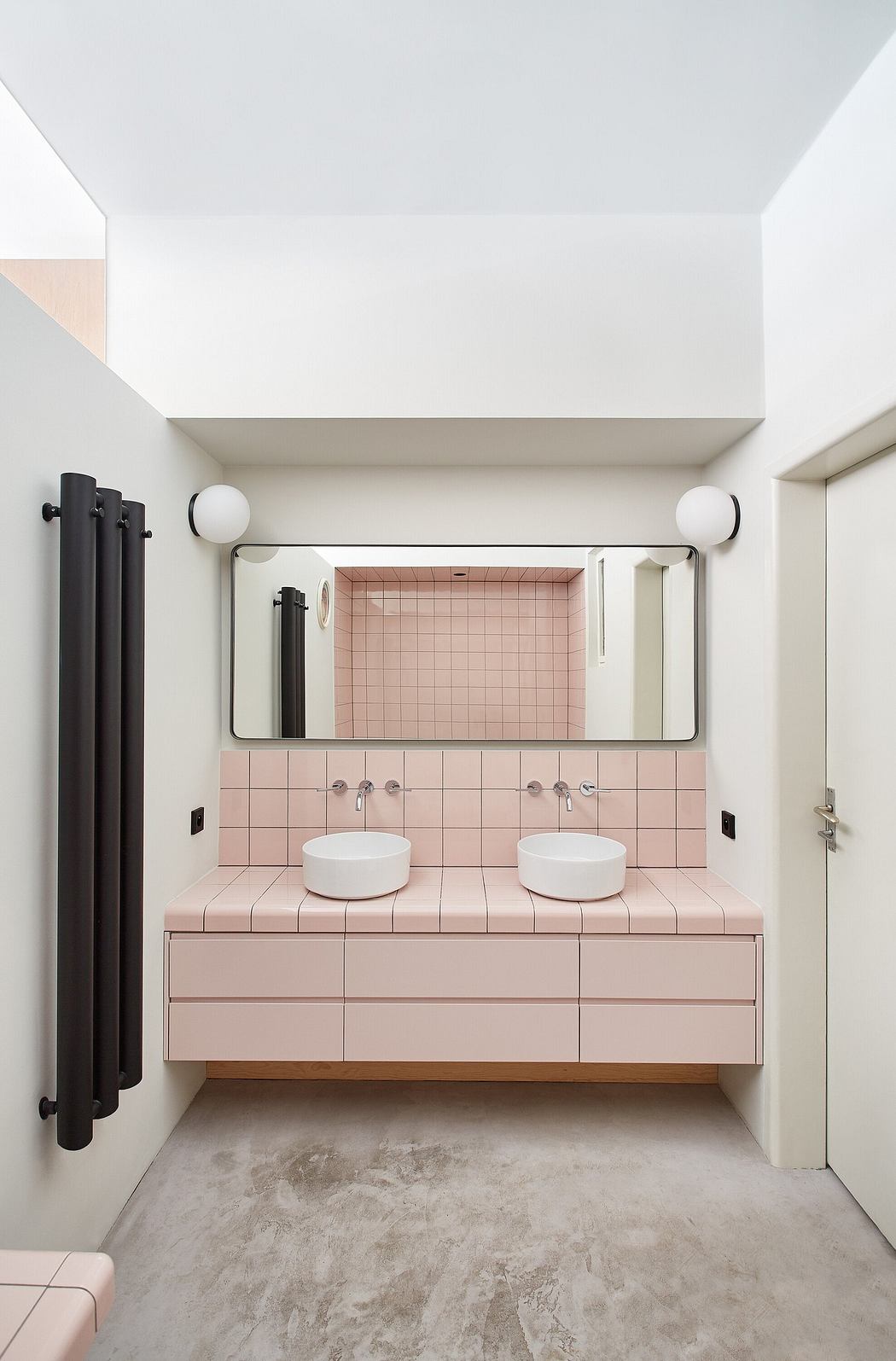 Contemporary pink-tiled bathroom with dual sinks and minimalistic design.