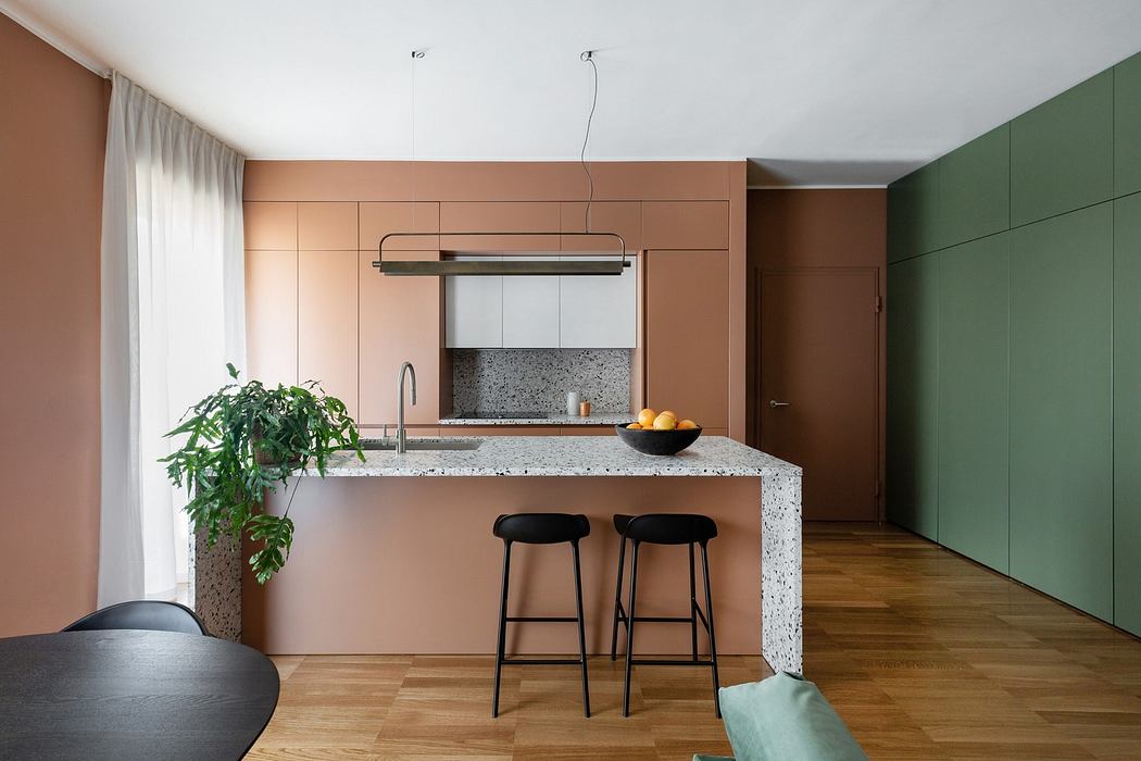 Modern kitchen with pink and green cabinets and a speckled countertop.