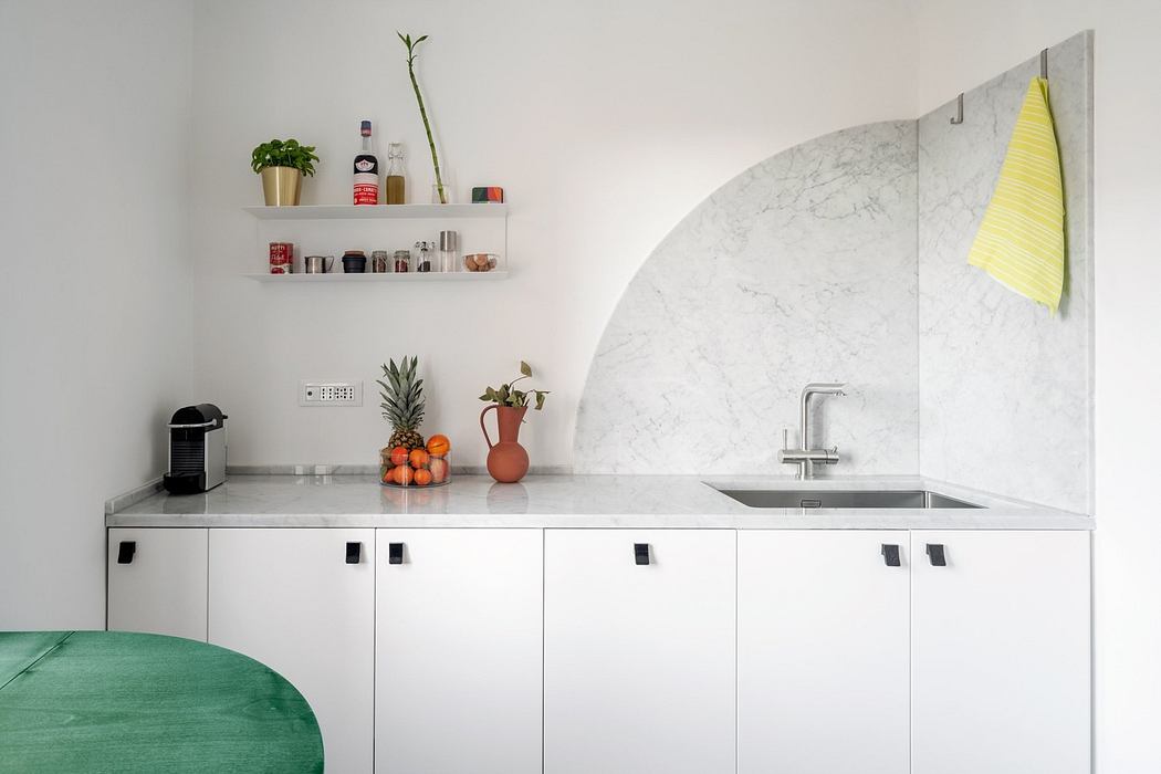 Modern kitchen corner with white cabinets and marble backsplash.