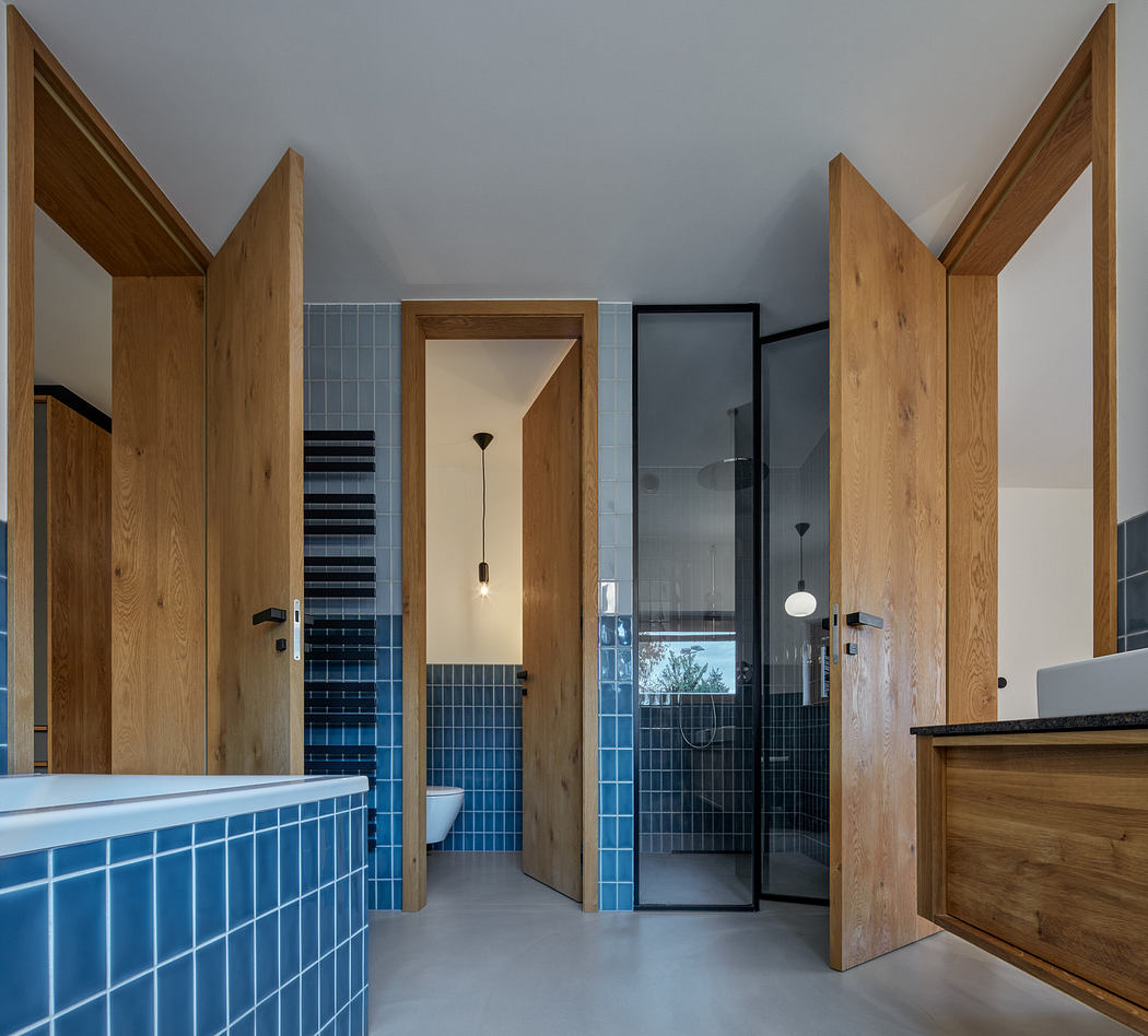 Modern bathroom with blue tiles and wooden doors.