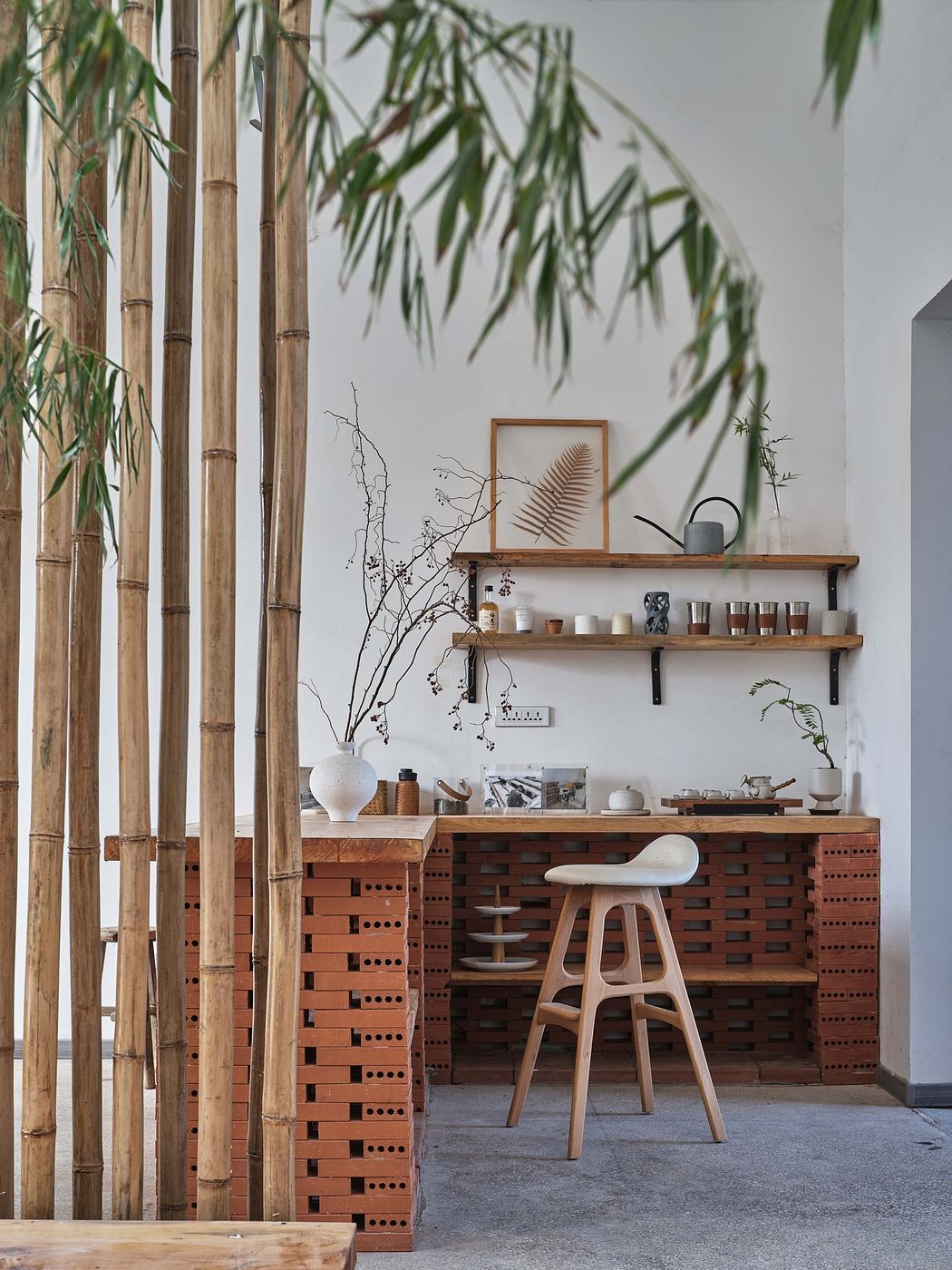 Minimalist interior with bamboo divider and wooden desk setup.