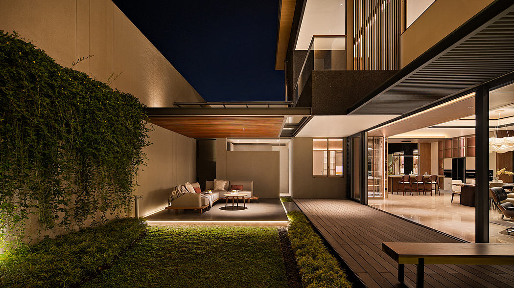 Modern house exterior at night with illuminated patio and garden.