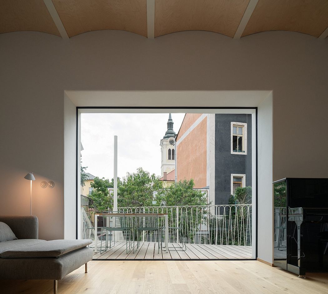 Minimalistic interior with large window overlooking cityscape.