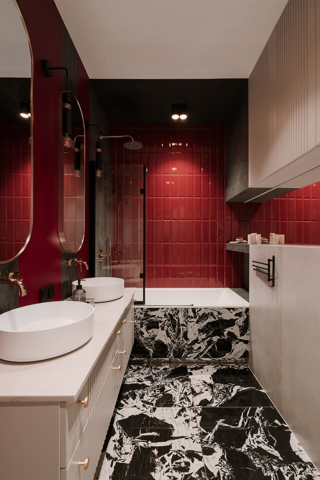 Modern bathroom with red tiled walls, black and white floor, and white fixtures.