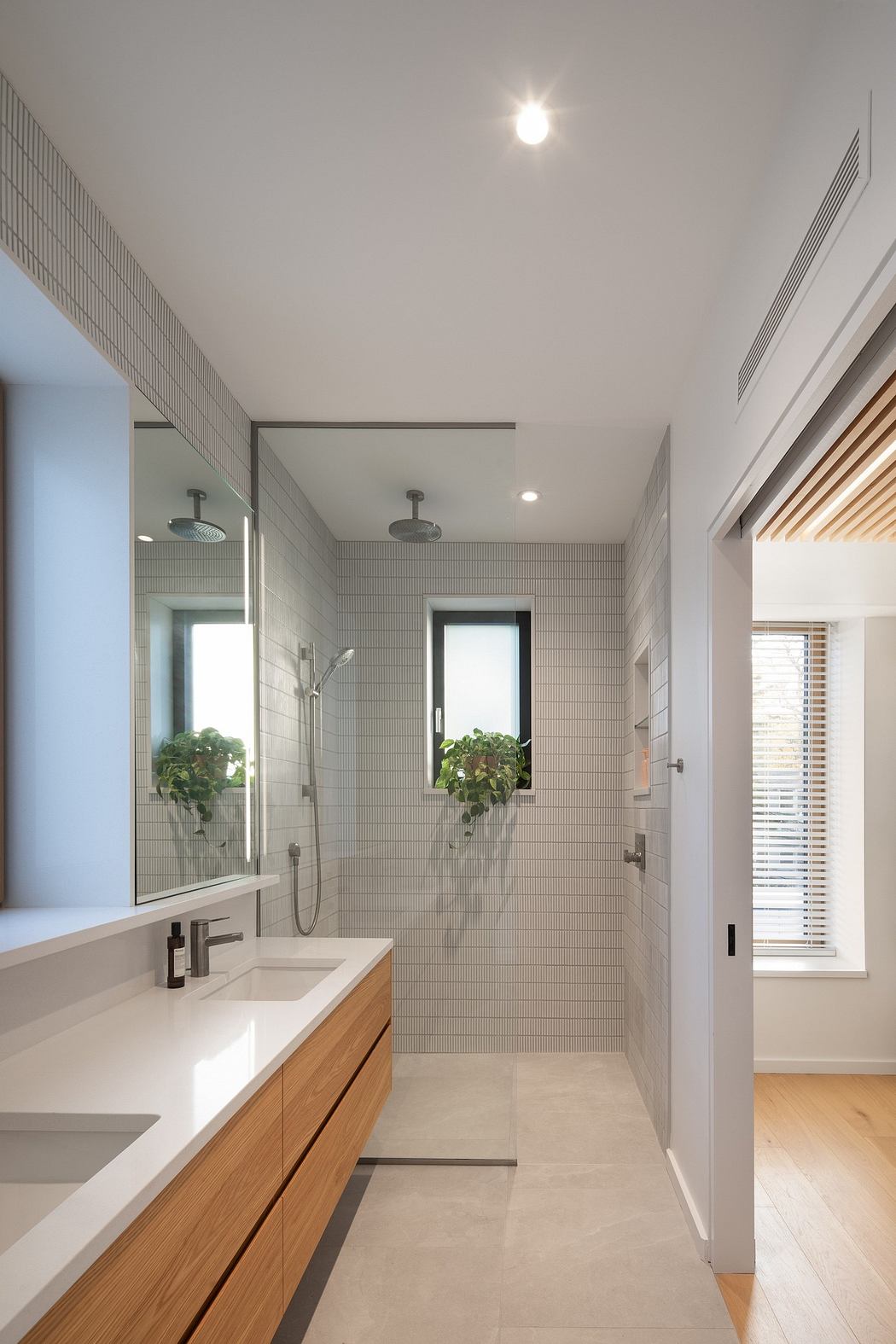 Sleek bathroom interior with glass shower and wooden accents.