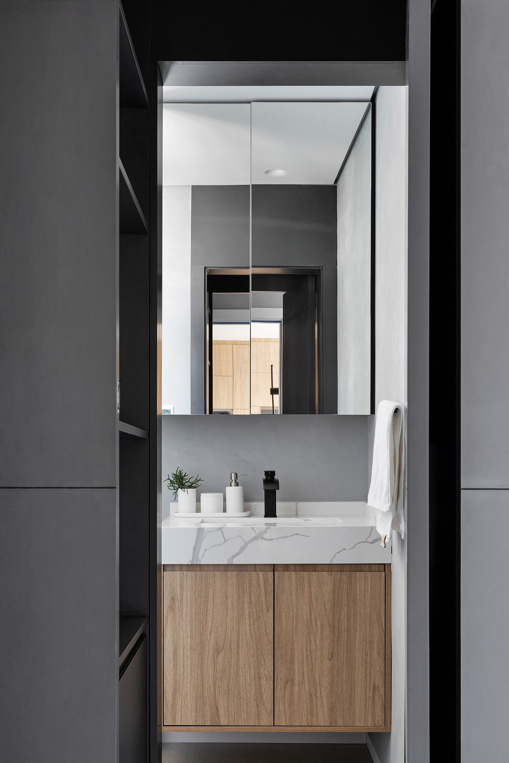 Contemporary bathroom with sleek wooden vanity and marble countertop.