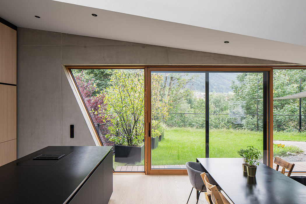 Modern kitchen with large windows overlooking a garden.