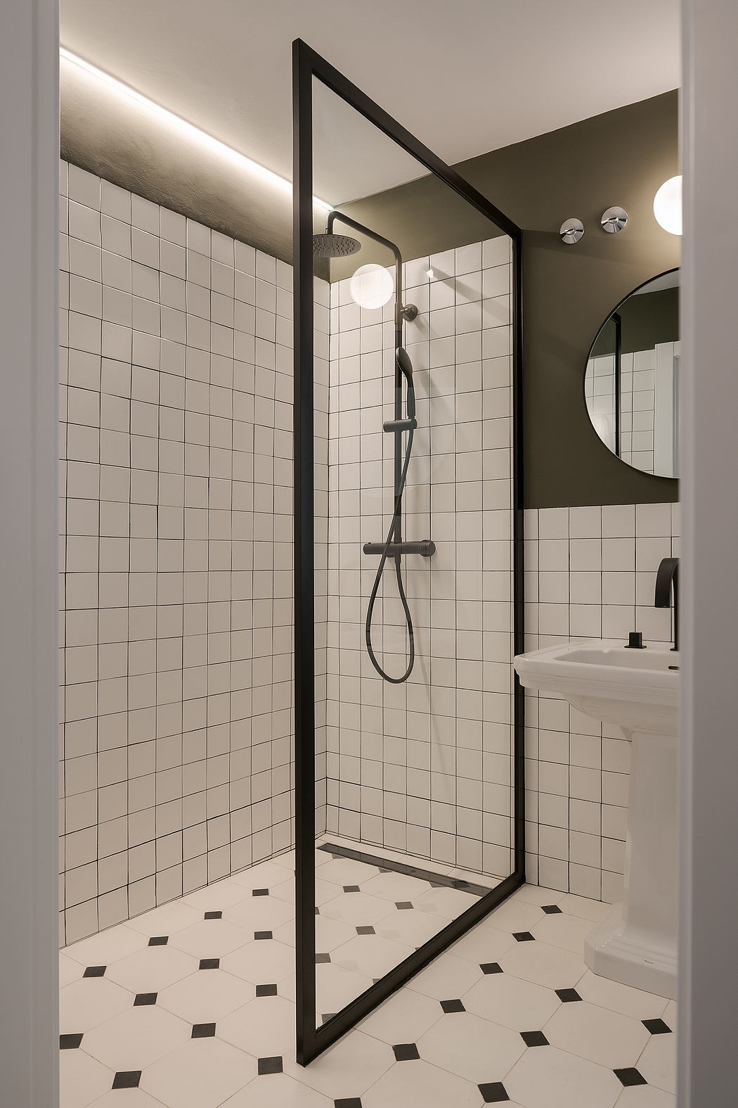 Sleek bathroom with tiled walls, patterned floor, and glass shower.