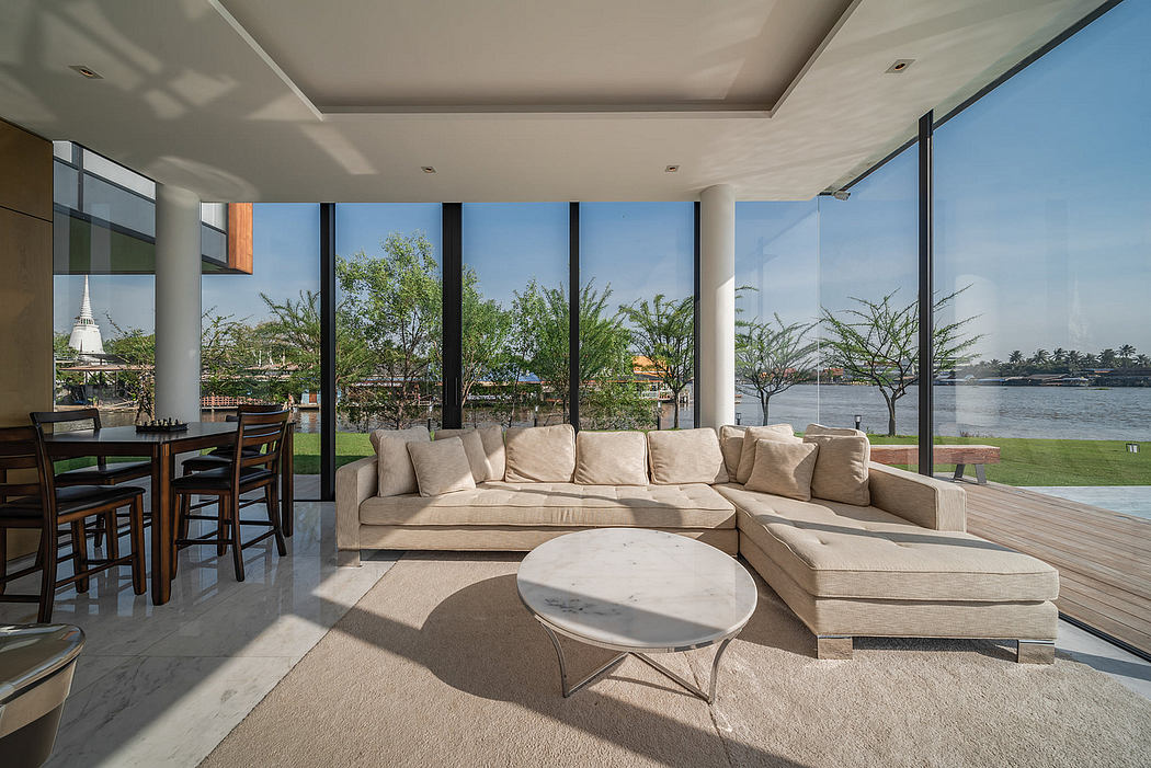 Modern living room with large windows overlooking a lake.
