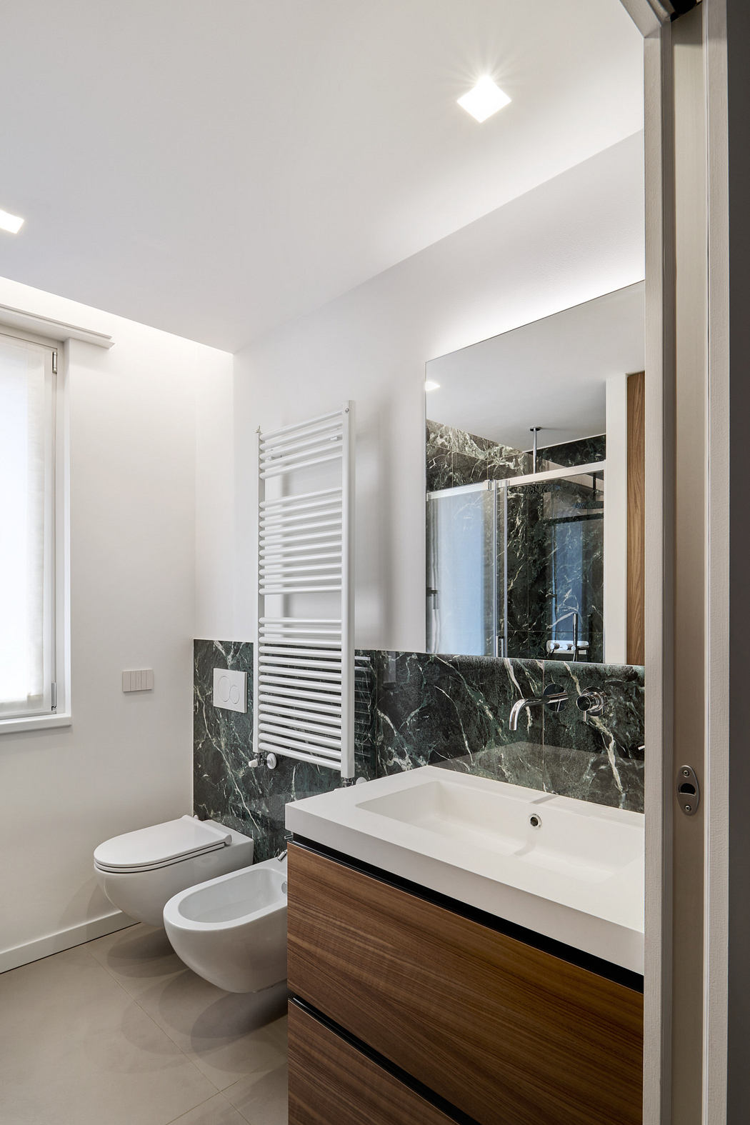 Contemporary bathroom with marble walls and sleek fixtures.