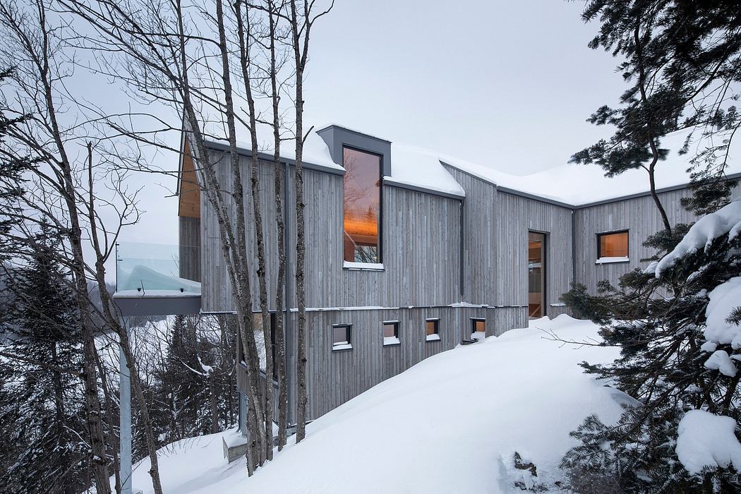 Contemporary wooden house with asymmetrical design in winter landscape.