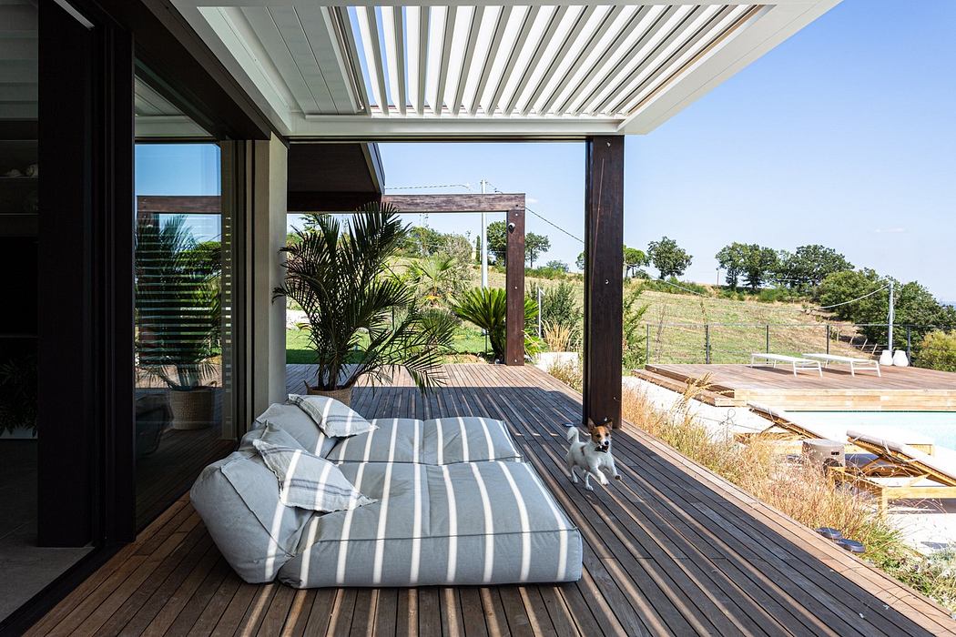 Contemporary patio with lounger, wooden deck, and slatted pergola.