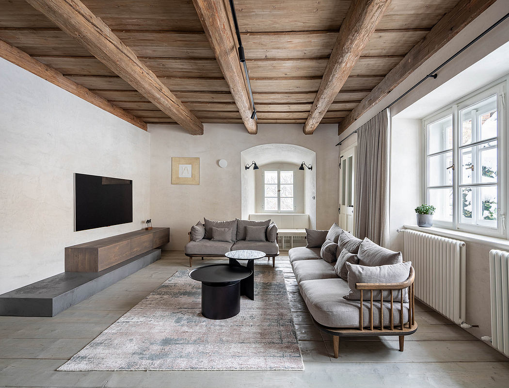 Elegant living room with exposed wooden beams and contemporary furnishings.