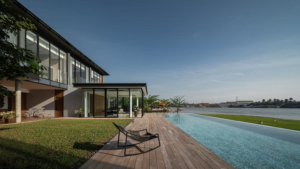 Modern house with large windows overlooking an infinity pool and river.