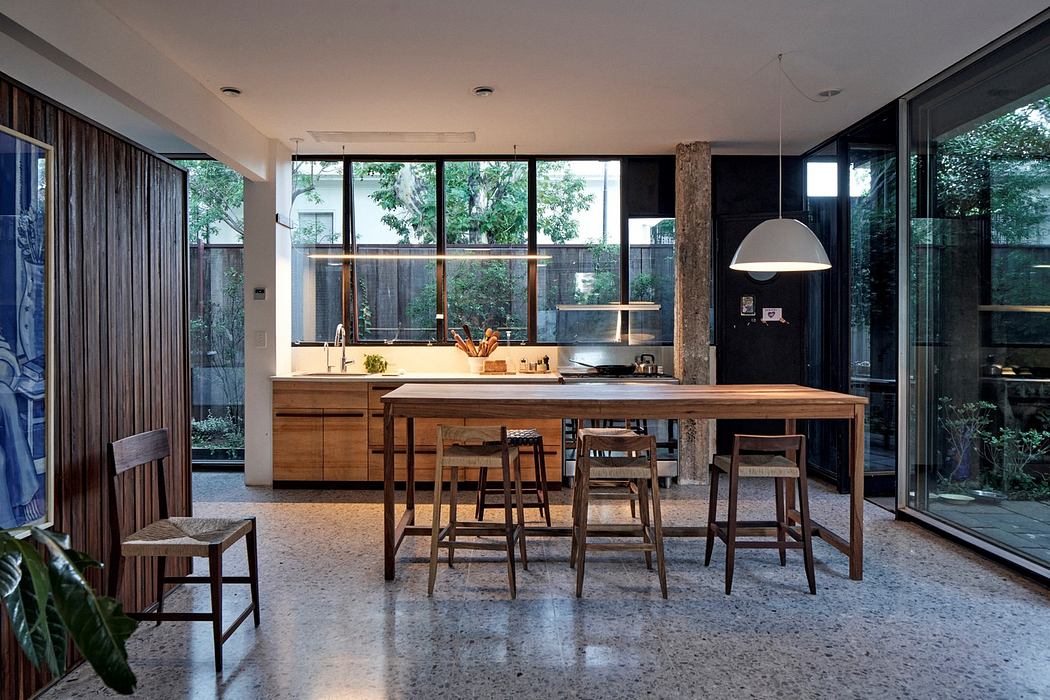 Modern kitchen with wooden furniture and large windows.