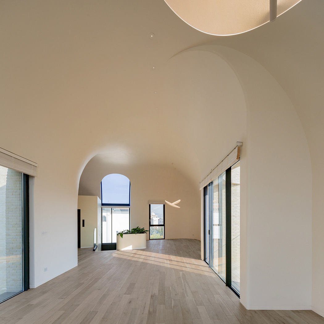 Minimalist interior with arched doorways and large windows.