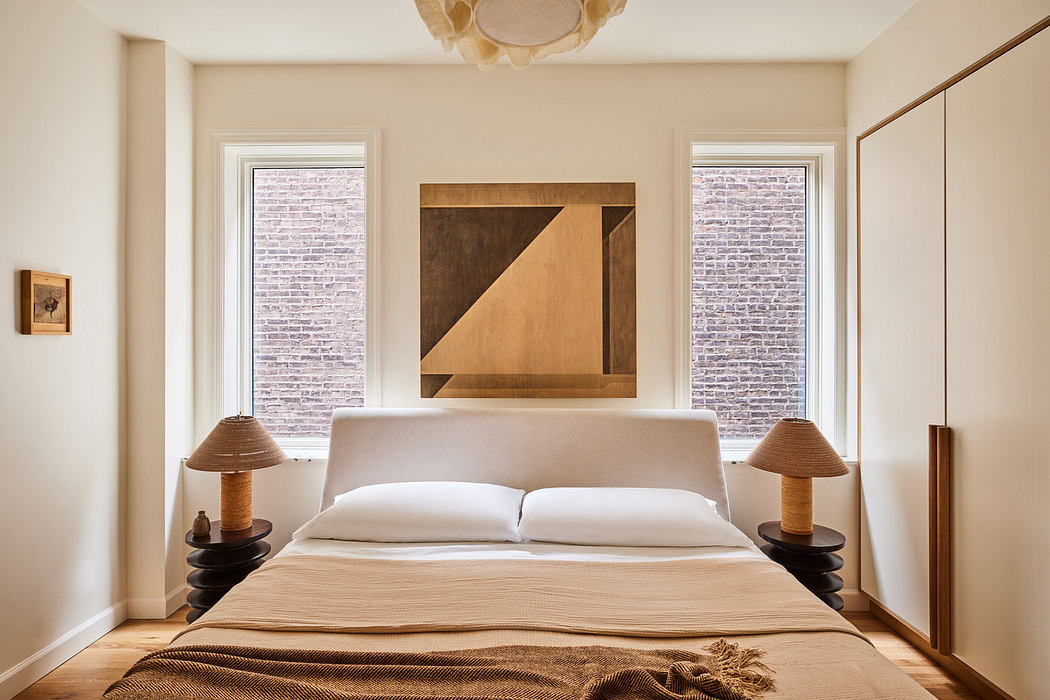 Minimalist bedroom with large bed, abstract wall art, and two windows.