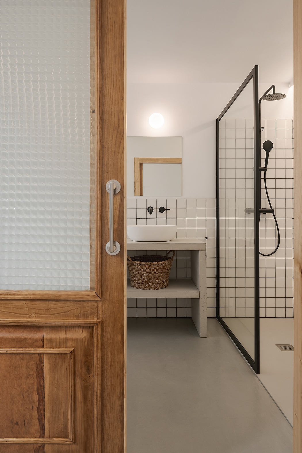 Modern bathroom interior with a glass shower and white sink.