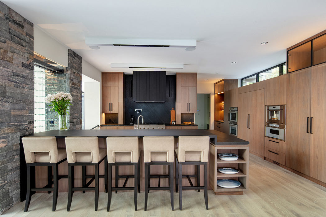 Contemporary kitchen with stone wall and wooden cabinetry.