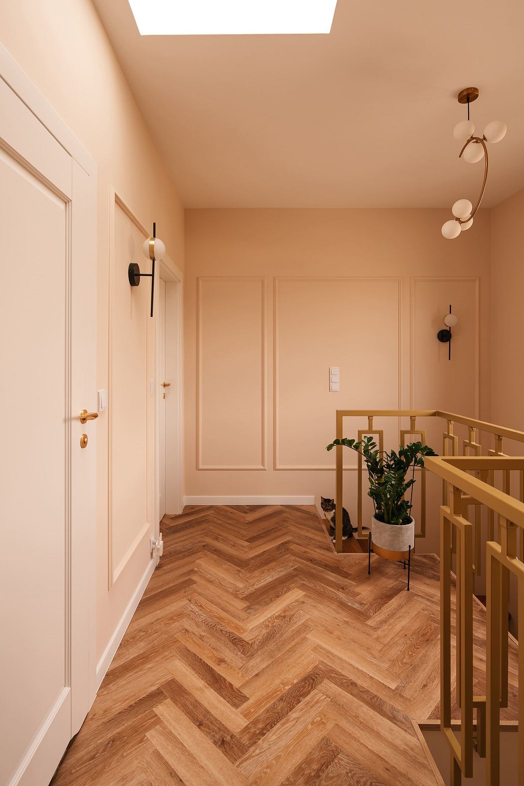 Elegant hallway with herringbone wood floor and pastel walls.