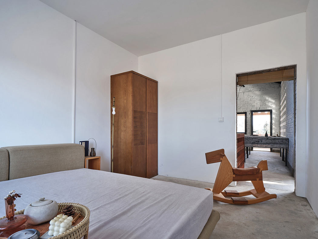 Minimalist bedroom with a bed, wooden wardrobe, and rocking horse.