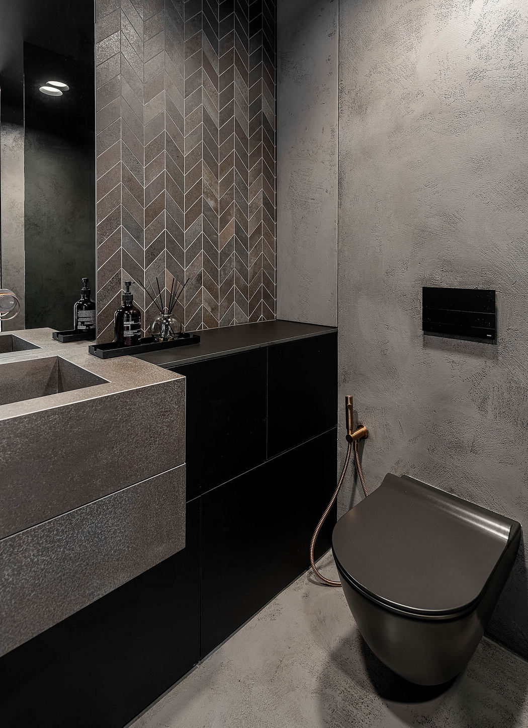 Modern bathroom with dark tones, wall-mounted toilet, and geometric tiles.