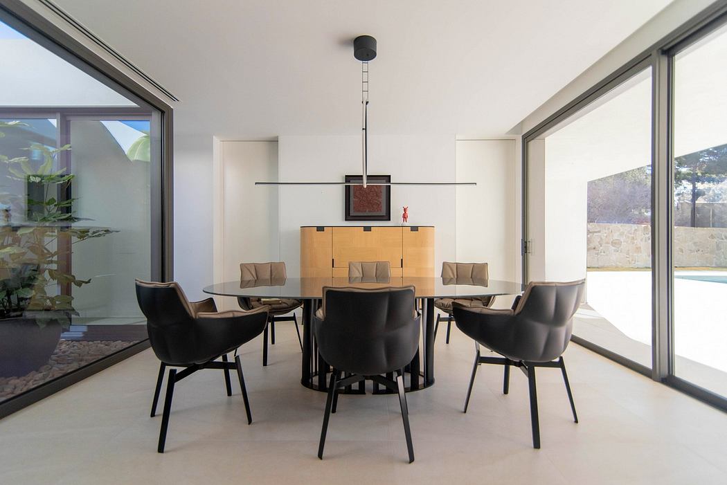 Modern dining room with a large table, black chairs, and floor-to-ceiling