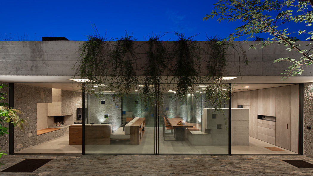 Sleek, contemporary house facade with glass walls and concrete overhang.