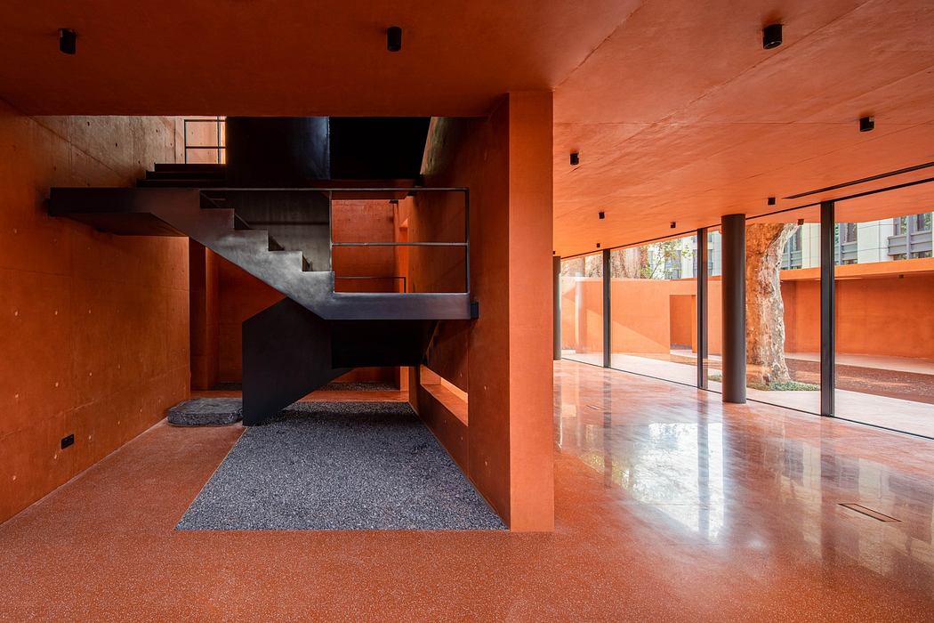 Contemporary orange interior with sleek black staircase and polished floors.