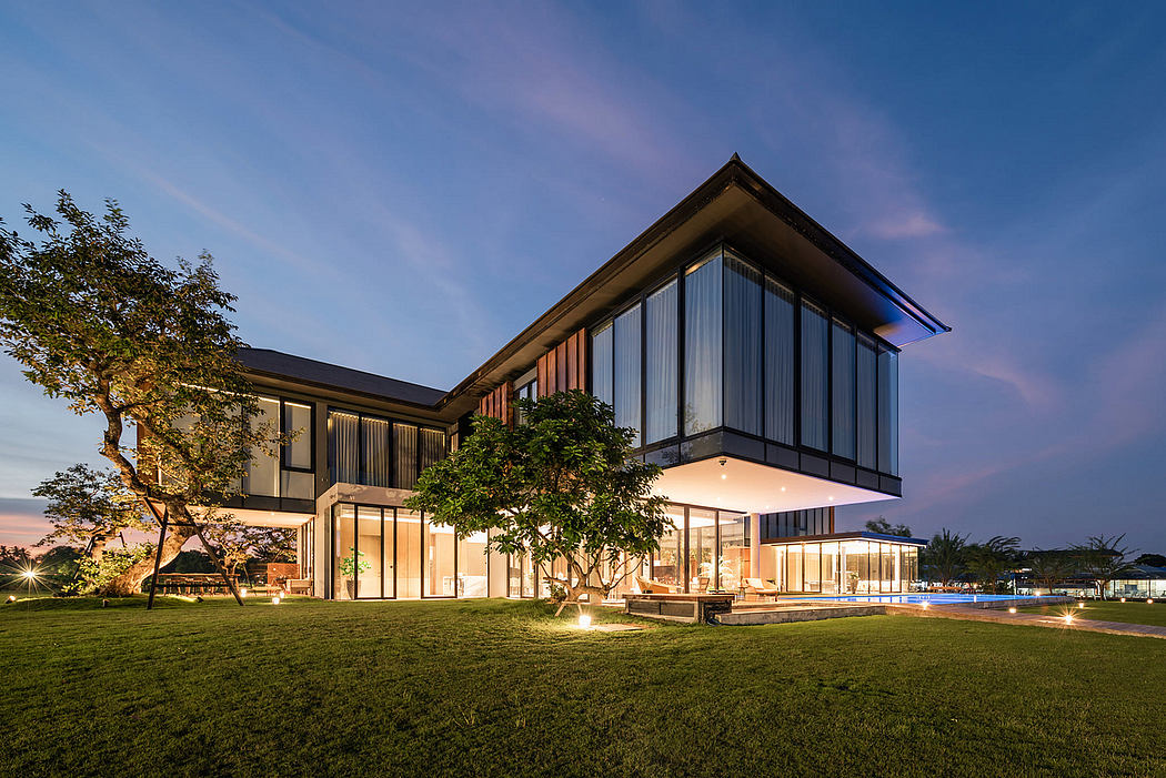 Modern house with large windows at dusk, illuminated from the inside.