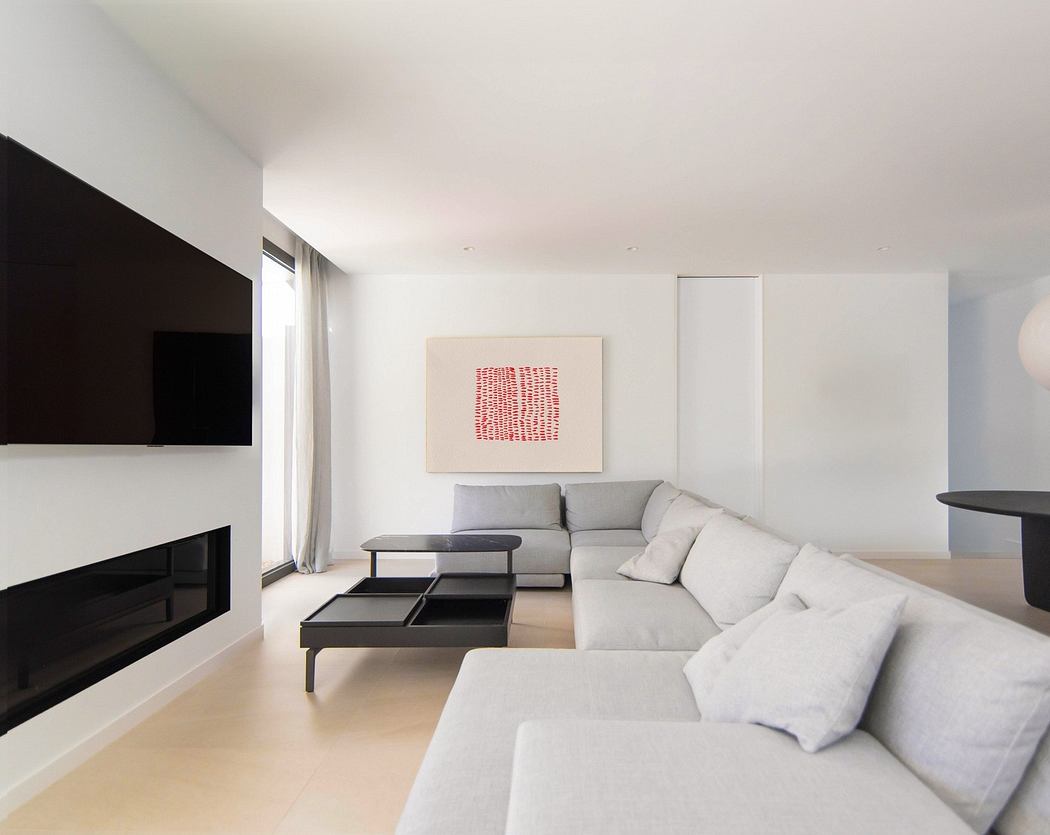 Modern minimalist living room with a large sofa, fireplace, and artwork on the wall