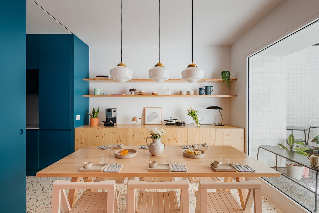 Contemporary kitchen with blue cabinets and wooden dining.