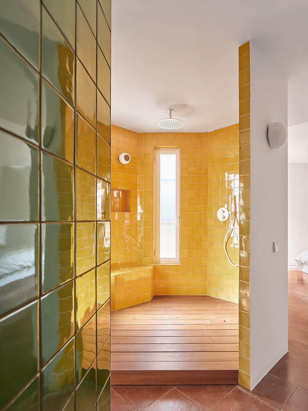 Modern bathroom with yellow tiles and wooden floor shower area.