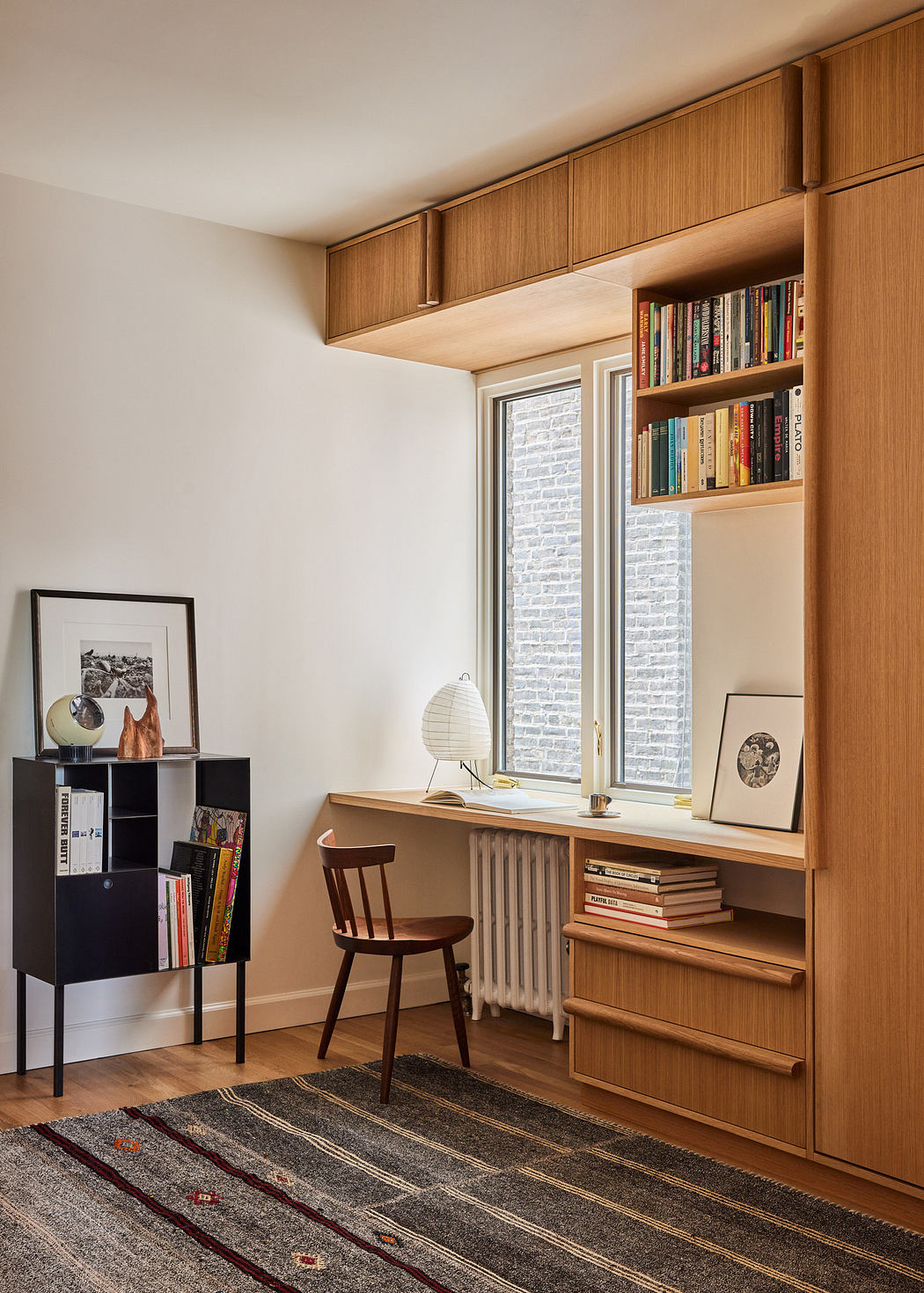 Cozy reading nook with built-in bookshelves and wooden desk by a