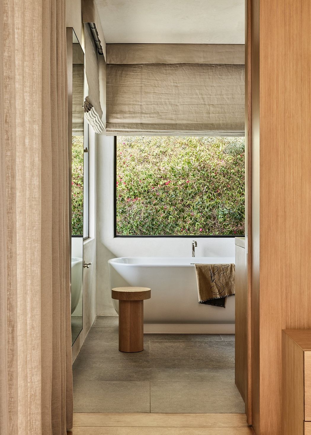 Minimalist bathroom with wooden accents and a garden view.