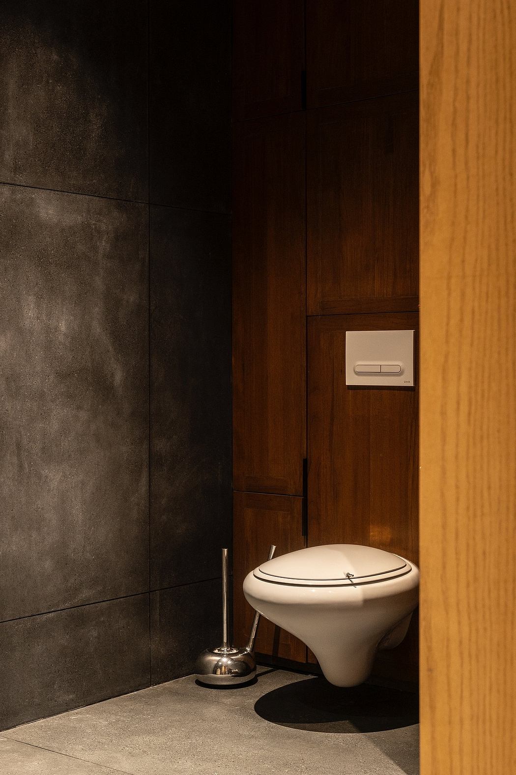 Modern bathroom with dark walls and a white toilet.